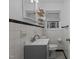 White tiled bathroom featuring a modern vanity, toilet, and decorative shelves at 900 Roxboro Road, Oxford, NC 27565