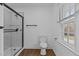 Modern bathroom featuring a glass-enclosed shower, wood-look flooring and a bright window at 900 Roxboro Road, Oxford, NC 27565