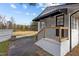 Charming home exterior featuring a black awning, brick foundation, and newly stained wooden porch railing at 900 Roxboro Road, Oxford, NC 27565