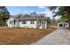 A charming white brick home complemented by a spacious driveway leading to a detached garage at 900 Roxboro Road, Oxford, NC 27565