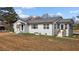 Side view of a white brick home showcasing manicured landscaping and a welcoming entrance at 900 Roxboro Road, Oxford, NC 27565
