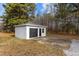 Exterior view of a detached garage with gray siding, a black garage door, and a concrete driveway at 900 Roxboro Road, Oxford, NC 27565