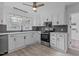 Well-lit kitchen with white cabinetry, stainless steel oven, and hexagon tile backsplash at 900 Roxboro Road, Oxford, NC 27565