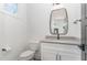 Modern powder room features a gray countertop vanity, black hardware, and a stylish rectangular mirror at 904 Harrison Ridge Rd, Wake Forest, NC 27587