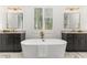 Modern bathroom with soaking tub, dual vanities, gold fixtures, and bright natural light at 904 Harrison Ridge Rd, Wake Forest, NC 27587