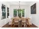 Cozy dining room with wood table, wicker chairs, chandelier, and natural light from large windows at 904 Harrison Ridge Rd, Wake Forest, NC 27587