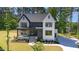 Stunning two-story home featuring a modern design, landscaped yard, and elegant entryway with stone and white plank siding at 904 Harrison Ridge Rd, Wake Forest, NC 27587