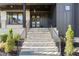 Inviting front porch with stone steps, black railings, and a stylish entrance with double doors at 904 Harrison Ridge Rd, Wake Forest, NC 27587