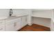Pantry space with white cabinets, quartz countertops, and hardwood floors at 904 Harrison Ridge Rd, Wake Forest, NC 27587