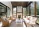 Cozy sunroom showcases a stone fireplace and comfortable seating for relaxing and entertaining at 904 Harrison Ridge Rd, Wake Forest, NC 27587