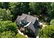 Aerial view of a beautiful home nestled among mature trees, showcasing its architectural details and private surroundings at 945 Jones Wynd, Wake Forest, NC 27587