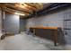 Unfinished basement featuring concrete walls, utility hookups, and a wooden workbench at 945 Jones Wynd, Wake Forest, NC 27587