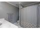 A bathroom with white tiling, a white double vanity, and a shower with a privacy curtain at 945 Jones Wynd, Wake Forest, NC 27587