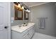 A bathroom featuring a double sink vanity with granite countertops, framed mirrors, and gray walls at 945 Jones Wynd, Wake Forest, NC 27587