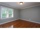 A well lit bedroom featuring hardwood floors and a window at 945 Jones Wynd, Wake Forest, NC 27587