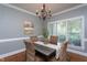 Dining room with wooden table, woven chairs, chandelier, and large window at 945 Jones Wynd, Wake Forest, NC 27587