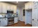 Charming kitchen features stainless steel appliances, granite countertops and white cabinets at 945 Jones Wynd, Wake Forest, NC 27587