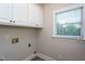 Laundry room with window, cabinets, and hookups for washer and dryer at 945 Jones Wynd, Wake Forest, NC 27587
