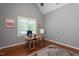 Bright home office featuring wood floors, gray walls, a large window, and a modern wooden desk at 945 Jones Wynd, Wake Forest, NC 27587