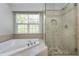 Bathroom featuring a soaking tub and a glass enclosed shower with neutral tile at 9508 Vira Dr, Raleigh, NC 27617