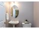 Powder room with pedestal sink, decorative mirror, and modern decor at 9508 Vira Dr, Raleigh, NC 27617
