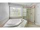 Beautiful bathroom with a soaking tub, glass shower, and large window at 9508 Vira Dr, Raleigh, NC 27617