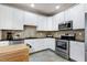 The kitchen features white cabinets, stainless steel appliances, granite countertops, and a tiled backsplash at 9508 Vira Dr, Raleigh, NC 27617