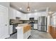 Modern kitchen with white cabinets, stainless steel appliances, a movable island, and tiled backsplash at 9508 Vira Dr, Raleigh, NC 27617