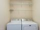Laundry room with white washer and dryer and wire shelving at 9508 Vira Dr, Raleigh, NC 27617