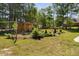A spacious backyard with lush landscaping, a covered pergola, and a volleyball net at 1006 Trumpet Vine Ct, Wendell, NC 27591