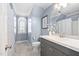 Bathroom featuring blue walls, modern vanity with a framed mirror, and arched window for natural light at 1006 Trumpet Vine Ct, Wendell, NC 27591