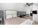 Cozy bedroom with a white four-poster bed, ceiling fan, and an adjacent room for a work area at 1006 Trumpet Vine Ct, Wendell, NC 27591