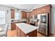 Kitchen features stainless steel appliances, hardwood floors and a center island with white countertop at 1006 Trumpet Vine Ct, Wendell, NC 27591