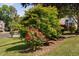 Beautifully landscaped front yard with colorful roses and manicured trees at 1006 Trumpet Vine Ct, Wendell, NC 27591