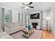 Living room with ceiling fan, a fireplace and built-in shelving with large windows for natural light at 1006 Trumpet Vine Ct, Wendell, NC 27591