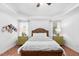 A bright main bedroom featuring a tray ceiling, hardwood floors, and green bedside tables at 1006 Trumpet Vine Ct, Wendell, NC 27591