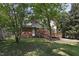 View of the house from the backyard with an expansive lawn and mature trees at 101 Atchison St, Garner, NC 27529