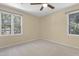 Bright bedroom featuring two large windows, a ceiling fan, neutral carpet and light beige walls at 101 Atchison St, Garner, NC 27529