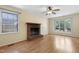 Spacious living room featuring a brick fireplace, large windows, wood floors, and a ceiling fan at 101 Atchison St, Garner, NC 27529