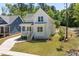 Stylish white farmhouse with manicured lawn, gray roof, and adjacent blue house at 1013 Forrestal Pl, Durham, NC 27707