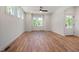 Bright living room with hardwood floors, white trim, and multiple windows overlooking the yard at 1013 Forrestal Pl, Durham, NC 27707