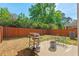 Backyard with a grill, a fire pit, fenced perimeter, and a lush green lawn at 1021 Sweet Cream Ct, Durham, NC 27703