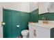 Stylish half-bathroom featuring a green accent wall, modern fixtures, and a vanity at 1021 Sweet Cream Ct, Durham, NC 27703
