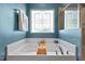 Close up of soaking tub, decorative window, and faucet at 1021 Sweet Cream Ct, Durham, NC 27703