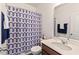Well-lit bathroom with a modern sink, toilet, and patterned shower curtain at 1021 Sweet Cream Ct, Durham, NC 27703