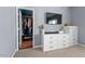 Bedroom features a large dresser, flat screen television, and a peek into the well-organized walk-in closet at 1021 Sweet Cream Ct, Durham, NC 27703