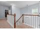 Upstairs hallway with neutral walls, carpet, and classic railing, creating a welcoming transition between rooms at 1021 Sweet Cream Ct, Durham, NC 27703