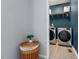 Laundry room with modern appliances, storage shelves, and stylish blue wall paint at 1021 Sweet Cream Ct, Durham, NC 27703