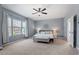 Spacious main bedroom with large windows, a ceiling fan, and neutral tones, providing a relaxing retreat at 1021 Sweet Cream Ct, Durham, NC 27703