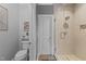 This renovated bathroom features a modern toilet and seamless glass shower with neutral tile and decor at 1037 Lila Ln, Raleigh, NC 27614